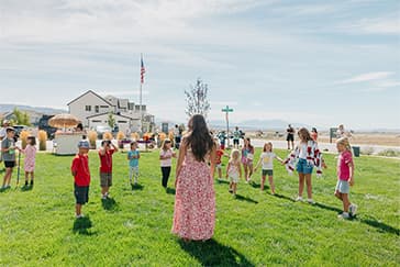 Children gathered on the grass for a Firefly activity